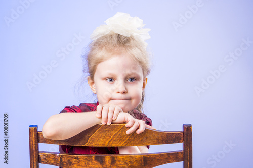 Portrait of dreaming little girl on chair