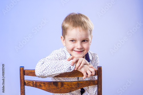 Portrait of cute smiling boy on chair