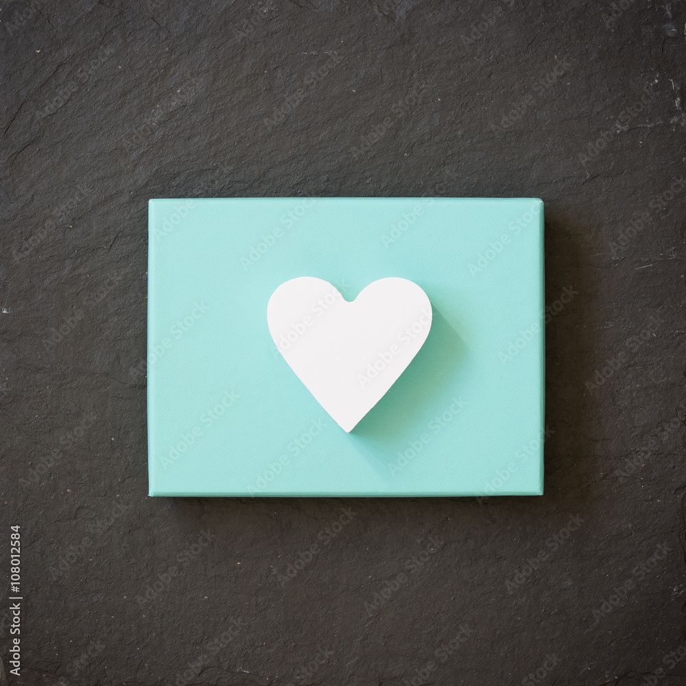 White heart on a turquoise color box on black background. Valentine's day. Present. Gift.