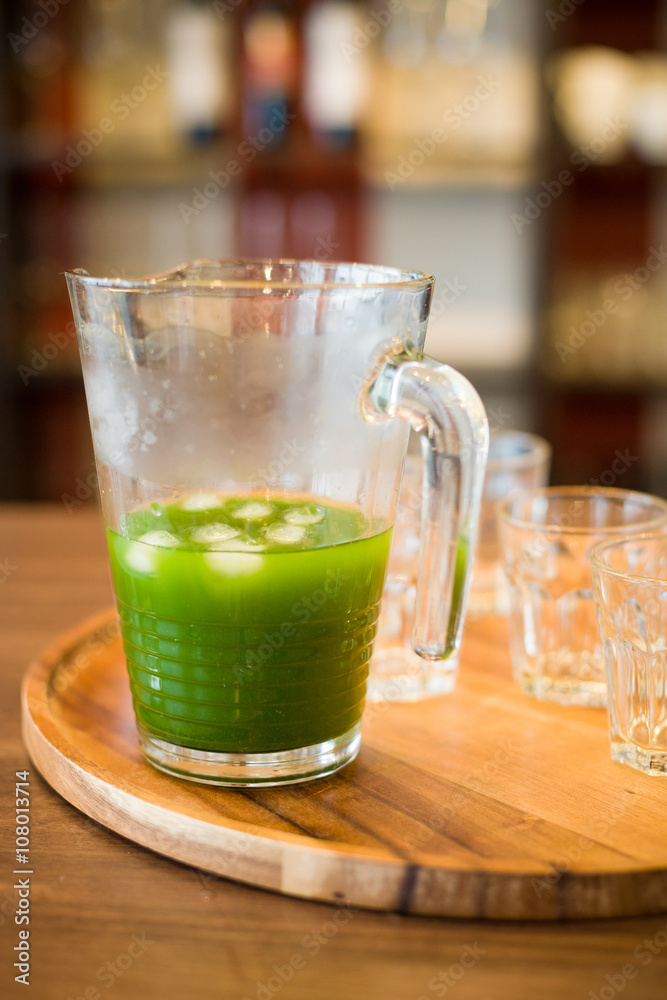 Healthy organic spinach, kale, green apple and celery smoothie with ice on wooden background. Summer drinks. Jar of spinach juice on wooden table, closeup Healthy organic spinach, kale, green apple and celery smoothie with ice on wooden background. Summer drinks. Jar of spinach juice on wooden table, closeup