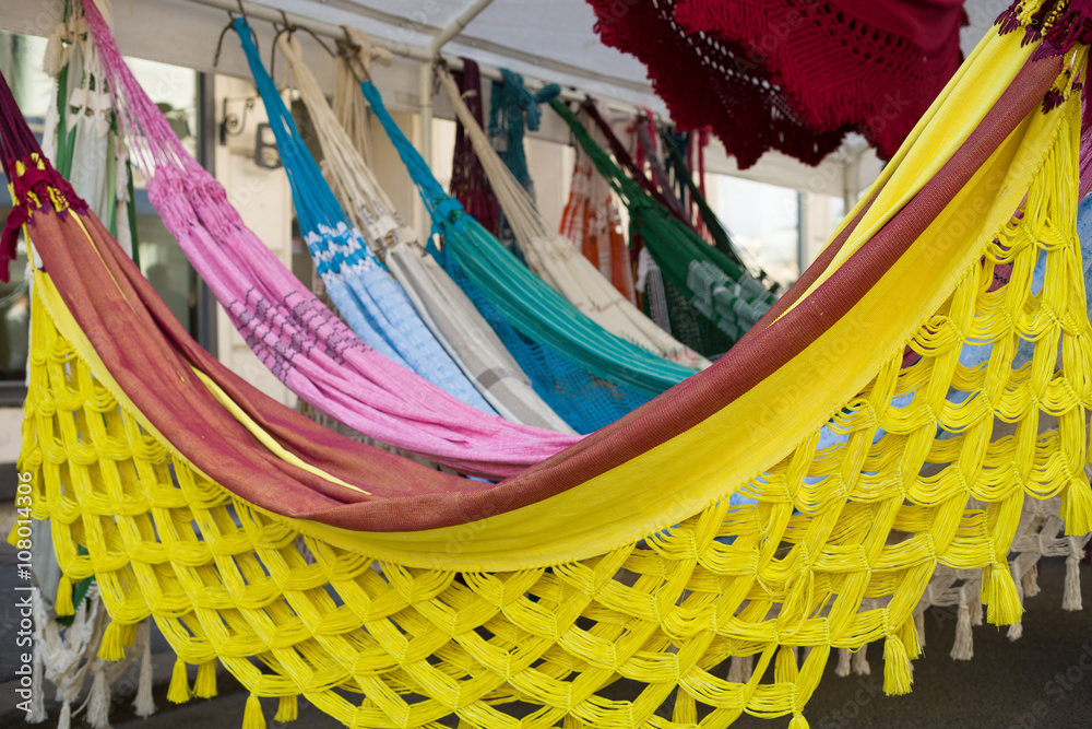 Bright ethnic hammocks with various pattern hanging in street market.