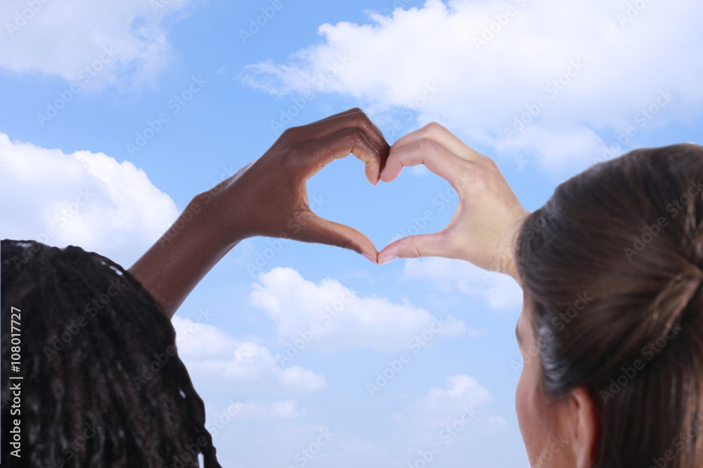 Schwarze und weiße Hand bilden ein Herz vor blauem Himmel Stock-Foto |  Adobe Stock