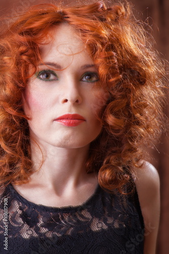 Portrait of beautiful woman with long curly red.