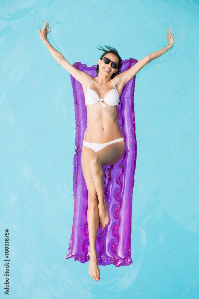 Fototapeta premium Young woman relaxing on inflatable raft