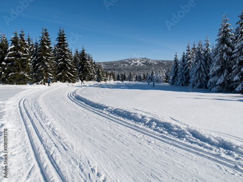 Sunny day on winter mountains with groomed cross-country trails