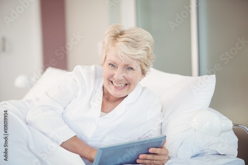 Portrait of happy senior woman using digital tablet