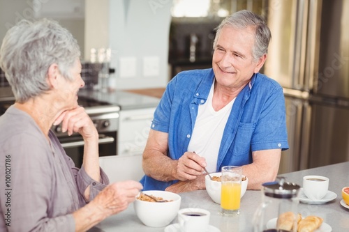 Happy senior couple talking while having breakfast