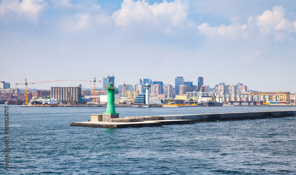 Naklejka premium Port of Naples, cityscape with green lighthouse