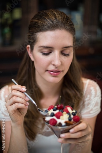 Happy woman enjoying desert with fruits