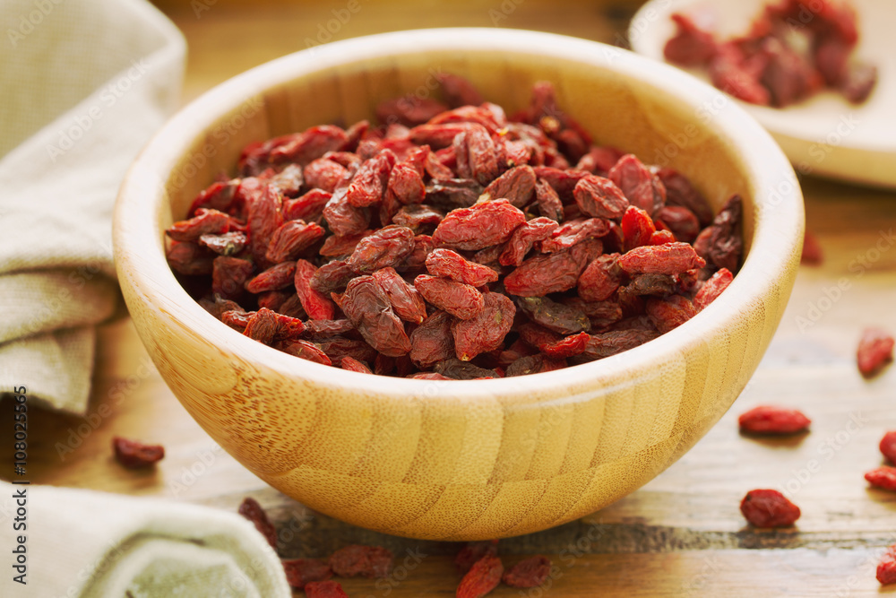 berries goji in bowl on brown wooden background berries goji in bowl on brown wooden background