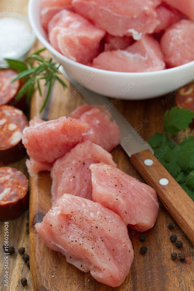 raw turkey owith black pepper on brown wooden board and chorizo raw turkey owith black pepper on brown wooden board and chorizo