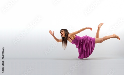 Tableau sur toile Woman fly - levitation with pink dress isolated white background