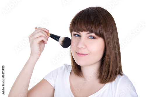 portrait of young beautiful woman applying make up with brush is