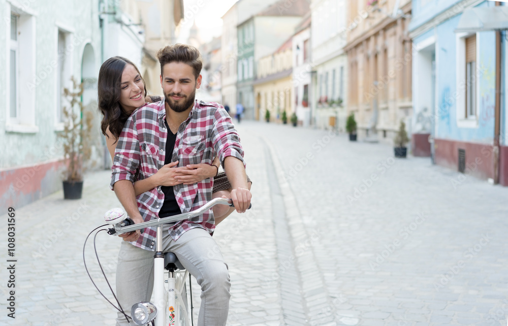 man on a bike with his girlfriend behind