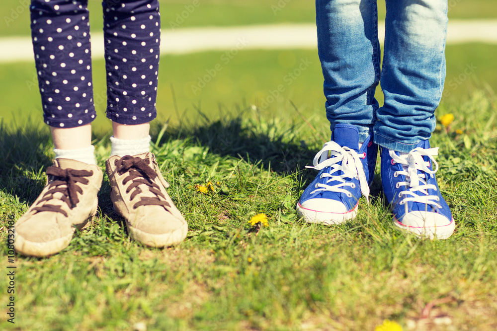 close up of kids legs in shoes on grass outdoors