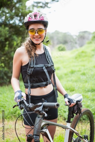 Smiling woman standing next to her bike © WavebreakMediaMicro