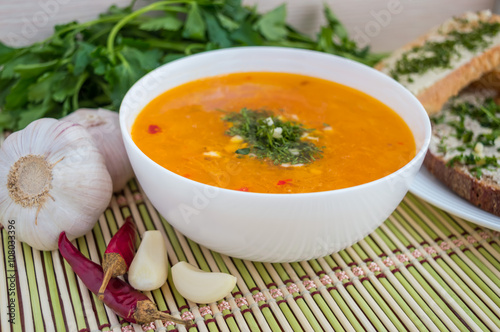 Traditional oriental soup with tomatoes, red lentils, green