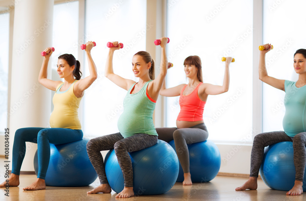 Fototapeta premium happy pregnant women exercising on fitball in gym