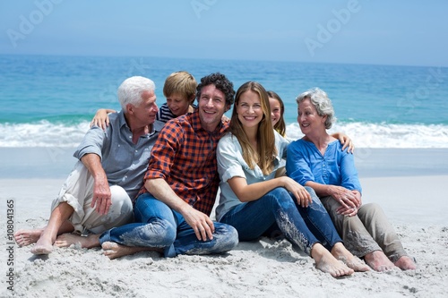 Multi-generation family smiling relaxing at sea shore