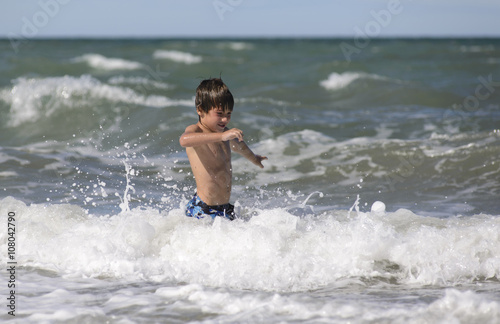 Niño Jugando entre las Olas del Mar