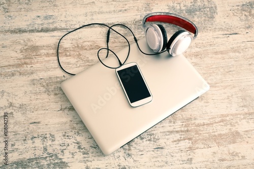 Headphones connected to a smartphone and a Laptop computer..