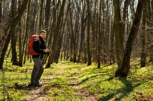 Male hiker looking to the side walking in forest © Aleksey