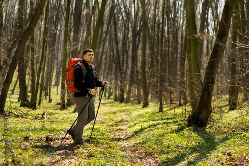 Male hiker looking to the side walking in forest