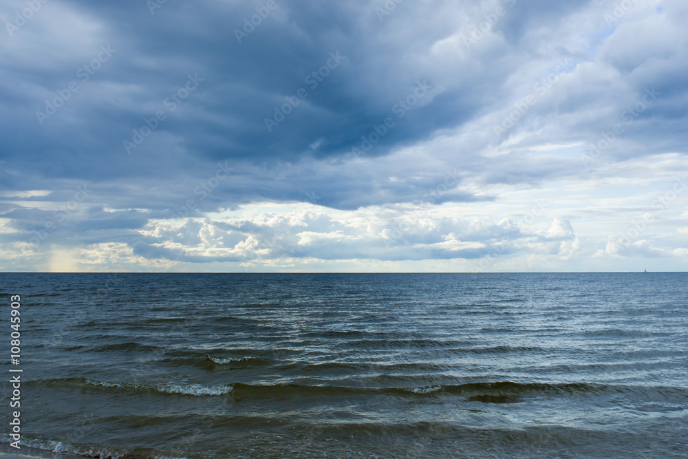 Rain clouds over Baltic sea near shoreline before sunset Rain clouds over Baltic sea near shoreline before sunset
