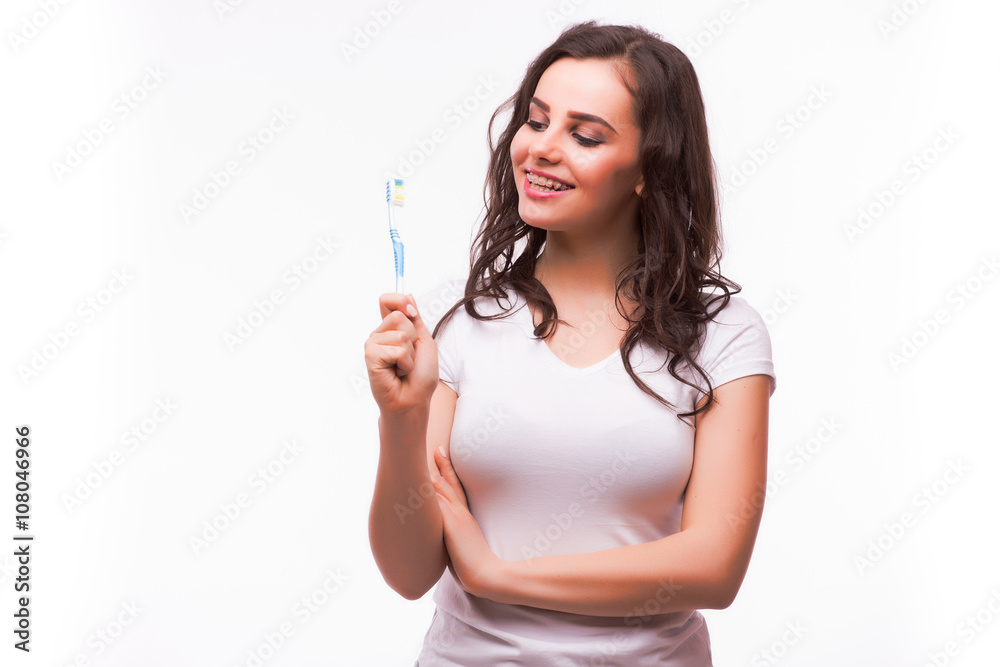 Portrait of a beautiful woman with braces on the teeth, cleans teeth with toothbrush, isolated on a white background Portrait of a beautiful woman with braces on the teeth, cleans teeth with toothbrush, isolated on a white background