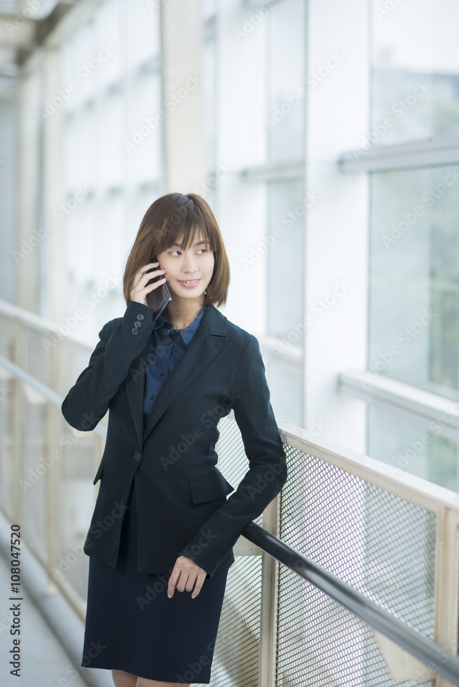 Attractive asian business woman using on smartphone outside Offi Attractive asian business woman using on smartphone outside Offi