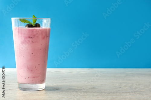 Blueberry smoothie in a glass on a blue background 