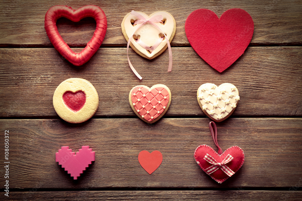 Set of cakes and decorative hearts on wooden background Set of cakes and decorative hearts on wooden background