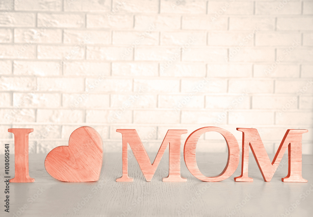Φωτογραφία I love mom inscription made of wooden letters with heart on light brick wall bac