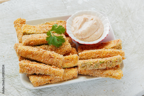 Fried zucchini breaded cheese and white sauce photo