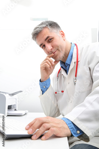 Uśmiechnięty lekarz patrzy w obiektyw 