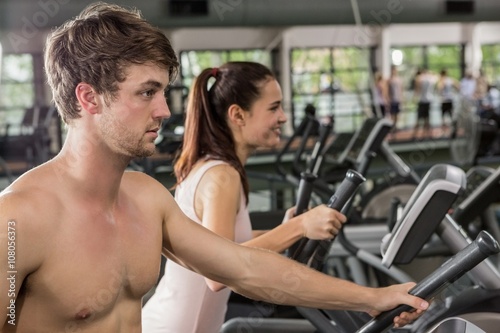 Man and woman exercising on the elliptical machine