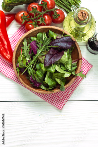 Fresh green salad with spinach ,ruccola,lettuce on wooden table.