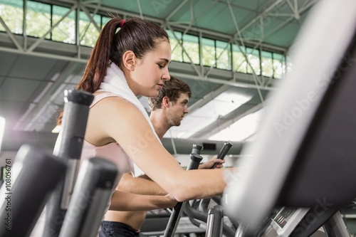 Woman and man exercising on the elliptical machine