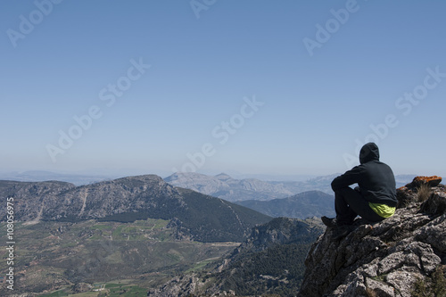 senderista que admira un paisaje montañoso con sensación de libertad en la naturaleza