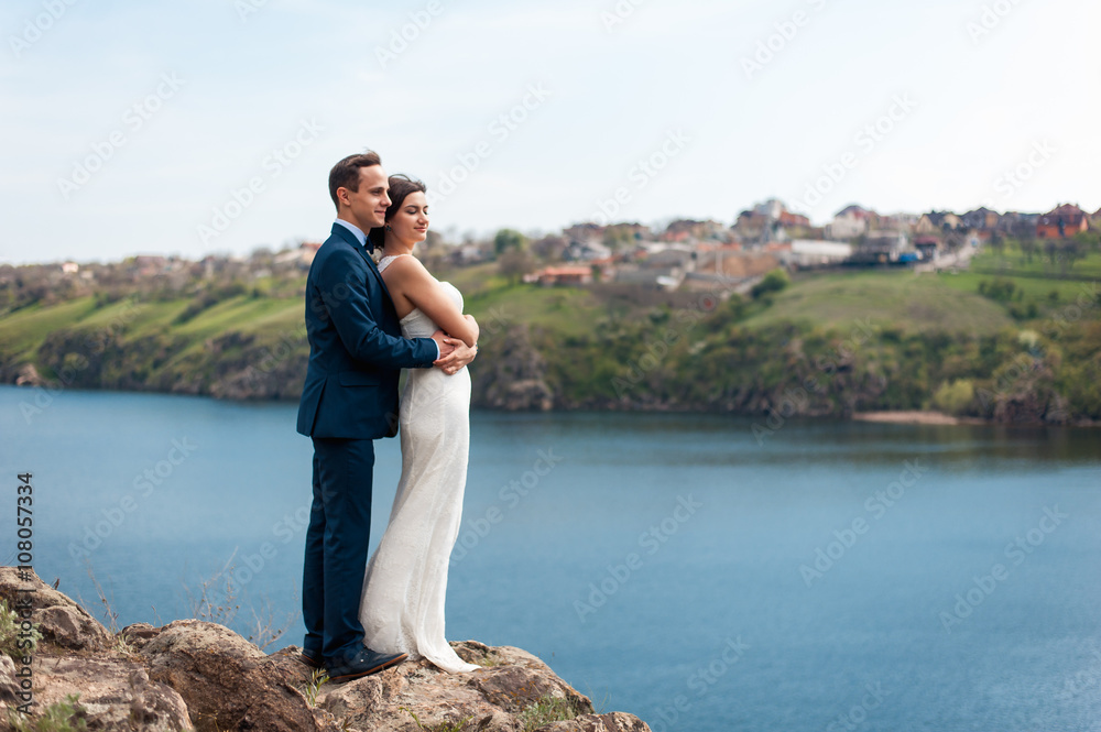 Fototapeta premium Bride and groom walking at the river