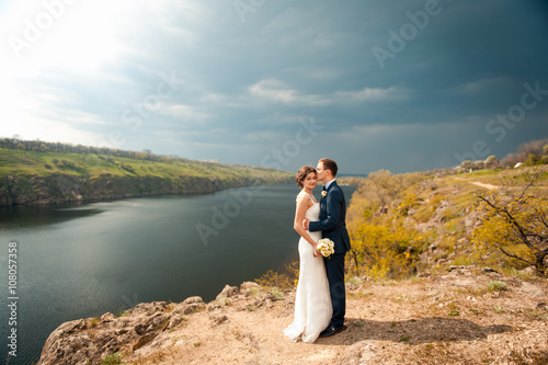 Bride and groom walking at the river