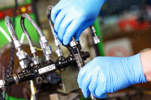 Bilde på lerret Professional mechanic testing diesel injector in his workshop.
