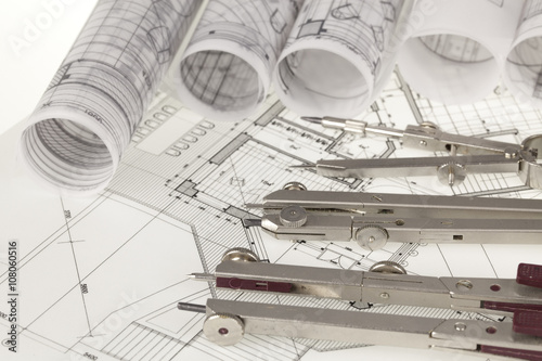 rolls of architecture blueprints, house plans & compasses