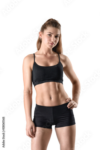 Front view of cutout young athletic woman holding her hands on waist and looking directly at the camera