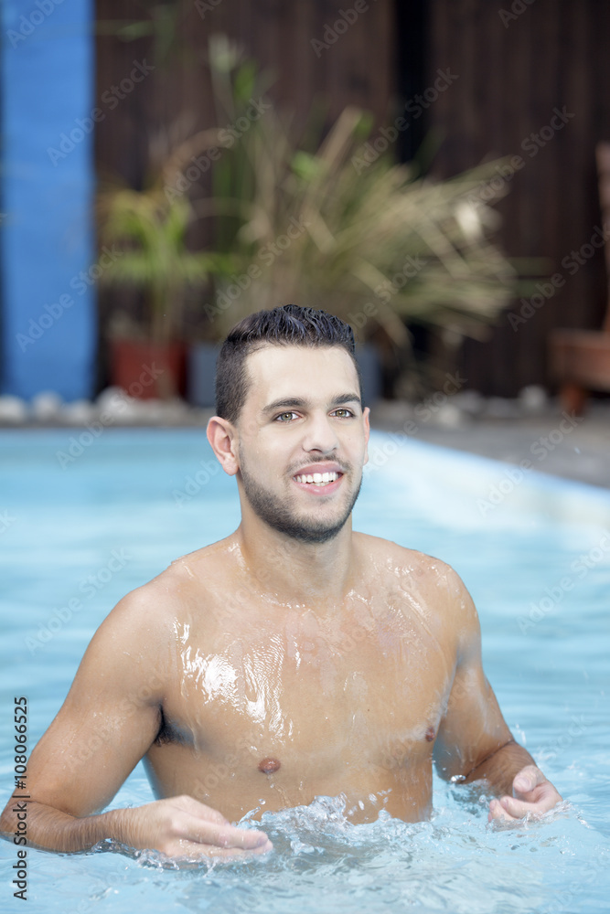Young man posing in the swimming pool Young man posing in the swimming pool