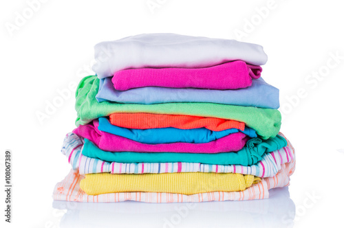Stack of clean colorful clothes on a light background.