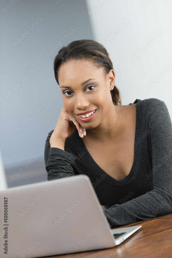 Mixed race woman using laptop at desk Mixed race woman using laptop at desk
