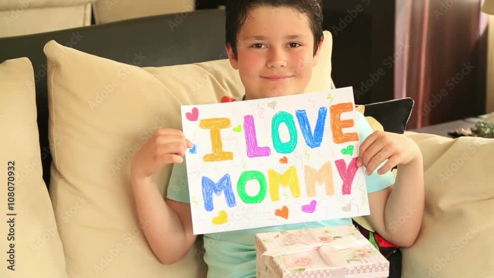 Young boy in blue shirt, with i love mom message board Young boy in blue shirt, with i love mom message board