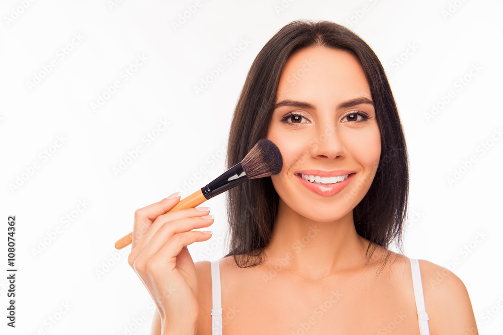 Nice smiling young woman holding makeup brush