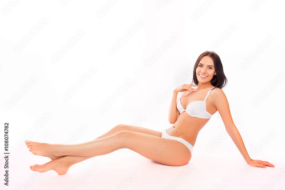 Happy smiling woman with perfect skin sitting in white underwear
